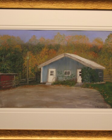 Chalk pastel landscape painting 'Doc Judy's Vet Clinic' by Deb Lathrop showing a small blue building, red barn, and a donkey behind a fence, featured at Hedgewood Galleries in Connersville, Indiana